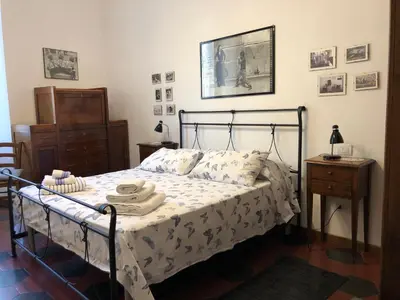 a bedroom with a bed with a black metal frame at Casa in Trastevere in Rome
