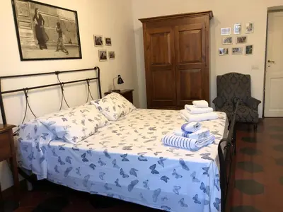 a bedroom with a bed with a blue comforter at Casa in Trastevere in Rome