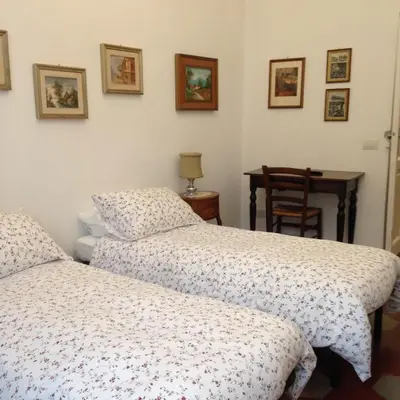 a bedroom with two beds and a table with a chair at Casa in Trastevere in Rome