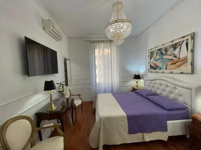 a bedroom with a purple bed and a chandelier at Bed And Breakfast King Plaza in Rome