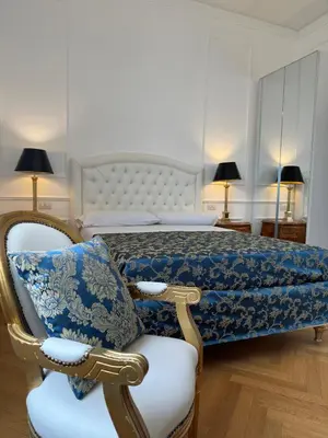 a bedroom with a bed and a chair with a pillow at Bed And Breakfast King Plaza in Rome