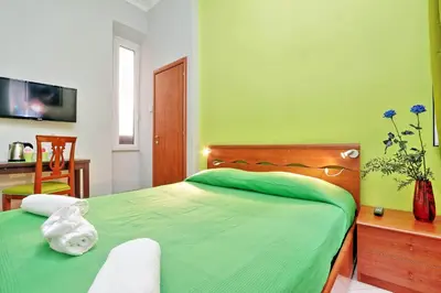 a green bedroom with a bed and a desk at Lucky Home rooms in Rome