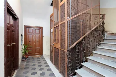 a hallway with stairs and a wooden door and a door at Lucky Home rooms in Rome