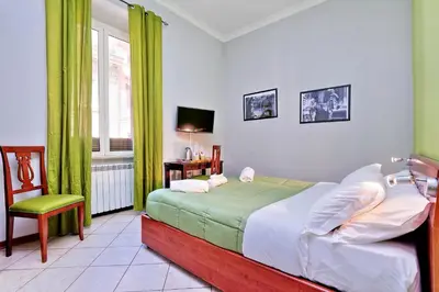 a bedroom with a bed and a chair and a window at Lucky Home rooms in Rome