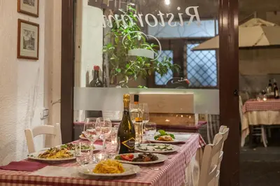 a table with plates of food and a bottle of wine at Monti Garden in Rome