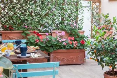 a patio with a table and some flowers and plants at Monti Garden in Rome