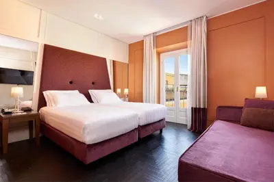 a hotel room with a bed and a couch at Mascagni Luxury Rooms & Suites in Rome