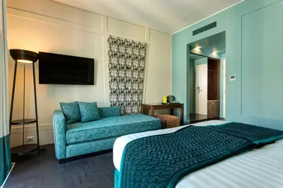 a hotel room with a bed and a couch at Mascagni Luxury Rooms & Suites in Rome