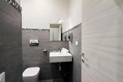 a bathroom with a sink and a toilet and a mirror at St. Peter Vatican Rooms in Rome