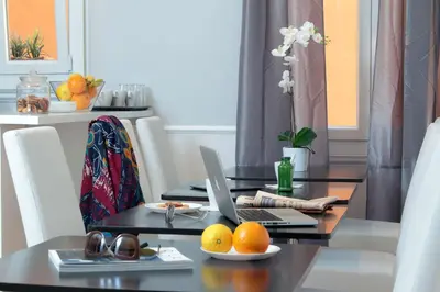 a dining room table with a laptop and oranges on it at St. Peter Vatican Rooms in Rome