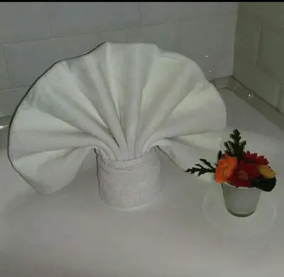 a white towel over a vase with flowers on a table at Velvet Suite in Rome