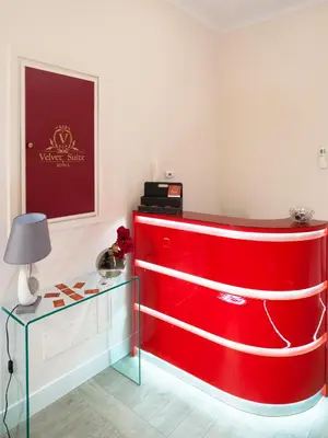 a red wall in a room with a table at Velvet Suite in Rome