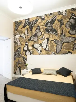 a bedroom with a wall with butterflies wallpaper at Velvet Suite in Rome