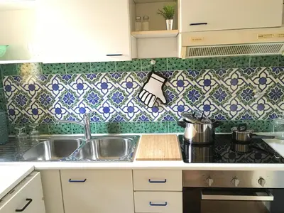 a kitchen with a sink and a tile wall at Domus Colosseum in Rome
