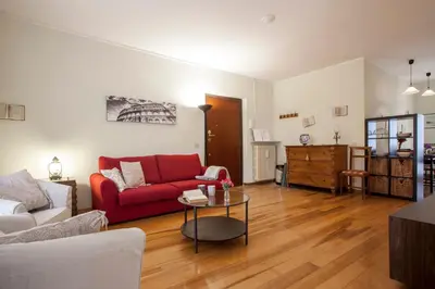 a living room with a red couch and a table at Domus Colosseum in Rome