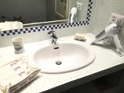a bathroom counter with a white sink and a mirror at Domus Colosseum in Rome