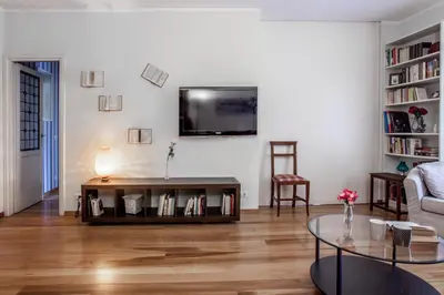 a living room with a table and a tv on a wall at Domus Colosseum in Rome