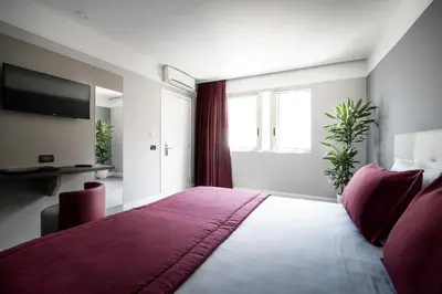 a bedroom with a large bed with a purple blanket at Hotel Varese in Rome