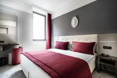 a bedroom with a large bed with red pillows at Hotel Varese in Rome