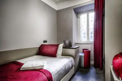 a small bedroom with a bed and a window at Hotel Varese in Rome