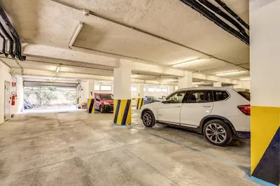 a parking lot with a white car parked in it at Ginevra Palace Hotel in Rome