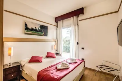 a bedroom with two beds and a window at Ginevra Palace Hotel in Rome