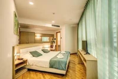 a bedroom with a large bed and a television at Ginevra Palace Hotel in Rome