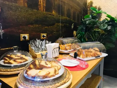 a table with several trays of food on it at Ginevra Palace Hotel in Rome