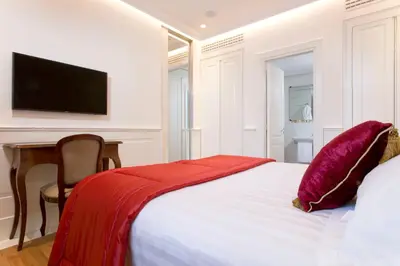 a bedroom with a bed and a desk and a television at Hotel Degli Artisti in Rome