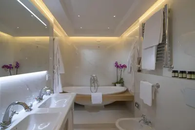 a white bathroom with two sinks and a tub at Hotel Degli Artisti in Rome