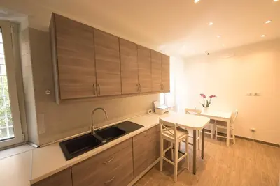 a kitchen with wooden cabinets and a table and a sink at BePlace Aventino in Rome