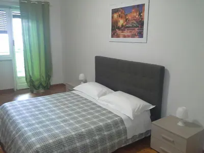a bedroom with a bed with a blanket and a picture on the wall at Olimpica Relais guest house in Rome
