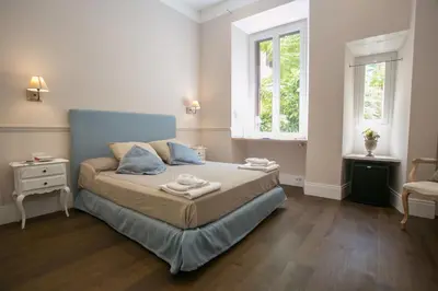 a small bedroom with a bed and two windows at Relais della Torre in Rome