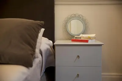 a bed with a dresser with a mirror on it at Relais della Torre in Rome