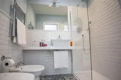 a bathroom with a toilet and a sink and a shower at Relais della Torre in Rome