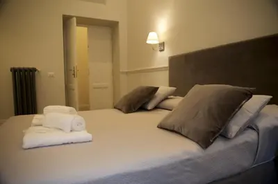 a bedroom with a large bed with towels on it at Relais della Torre in Rome