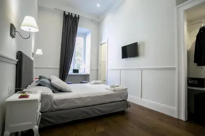 a bedroom with a bed and a tv on a wall at Relais della Torre in Rome