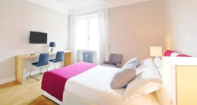 a bedroom with a bed and a desk and a television at Adamas Luxury Suite in Rome