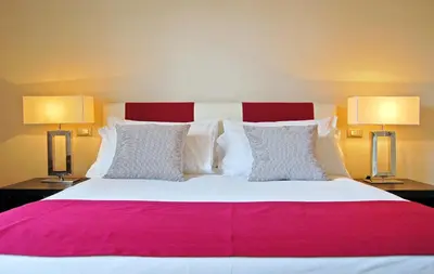 a bedroom with a large bed with two lamps at Adamas Luxury Suite in Rome