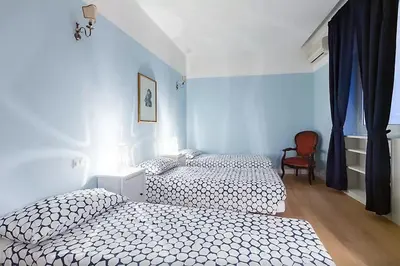 a bedroom with two beds and a chair at Exclusive apartment a few steps from the Spanish Steps in Rome