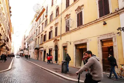 a man walking down a street in a city at Exclusive apartment a few steps from the Spanish Steps in Rome