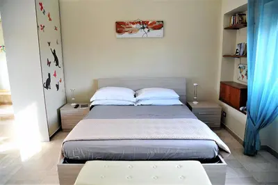 a bedroom with a large bed with blue curtains at Attico luminoso terrazza Metro A Aria Cond WiFi in Rome