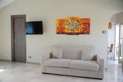 a living room with a couch and a painting on the wall at Attico luminoso terrazza Metro A Aria Cond WiFi in Rome