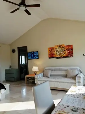 a living room with a couch and a ceiling fan at Attico luminoso terrazza Metro A Aria Cond WiFi in Rome