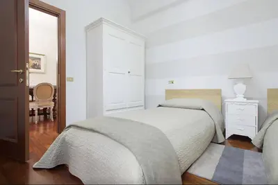a white bedroom with a bed and a dresser at Holidays Banchi Nuovi in Rome