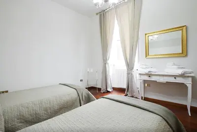 a bedroom with two beds and a desk and a mirror at Holidays Banchi Nuovi in Rome