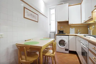 a kitchen with a table and a washing machine at Holidays Banchi Nuovi in Rome