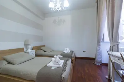 a bedroom with two beds and a stuffed animal on the couch at Holidays Banchi Nuovi in Rome