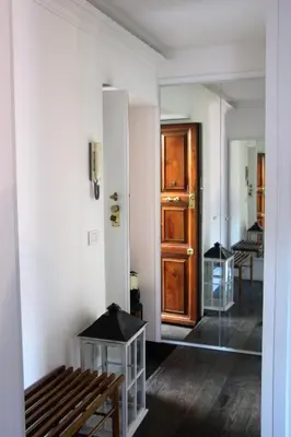 a hallway with a wooden door and a wooden bench at La Rosa del Vaticano Luxury Apartment in Rome