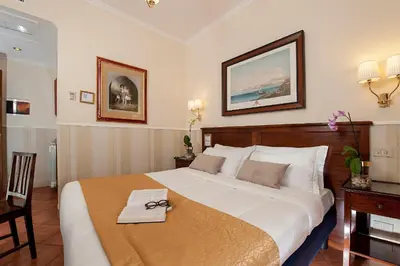 a bedroom with a large bed with a pair of glasses on it at Budget Rooms Des Arts in Rome